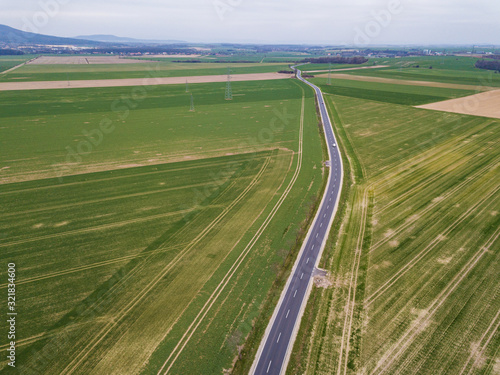 Aerial view on the highway between the green fields