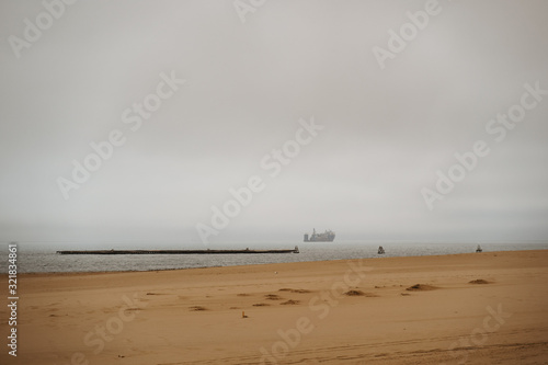 shore coast with oil tankers on the sea in bad weather with stormy clouds