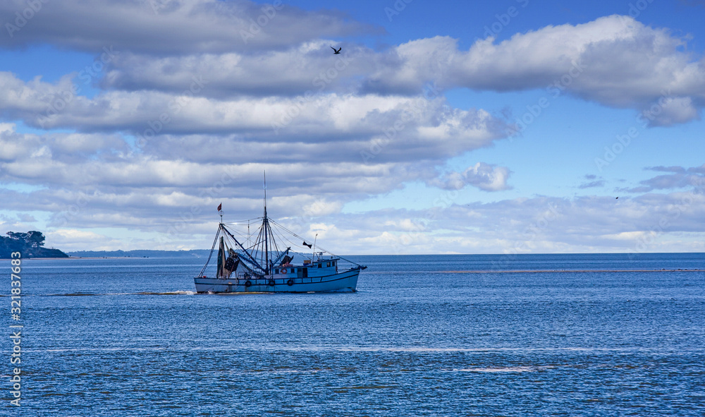 A shrimp boat heading out into the bay in the morning