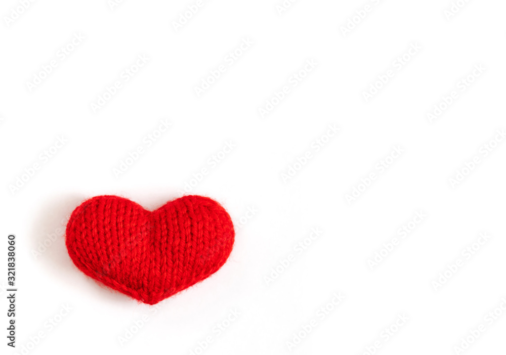 Red knitted heart on a white background. Valentines day or mothers day background.