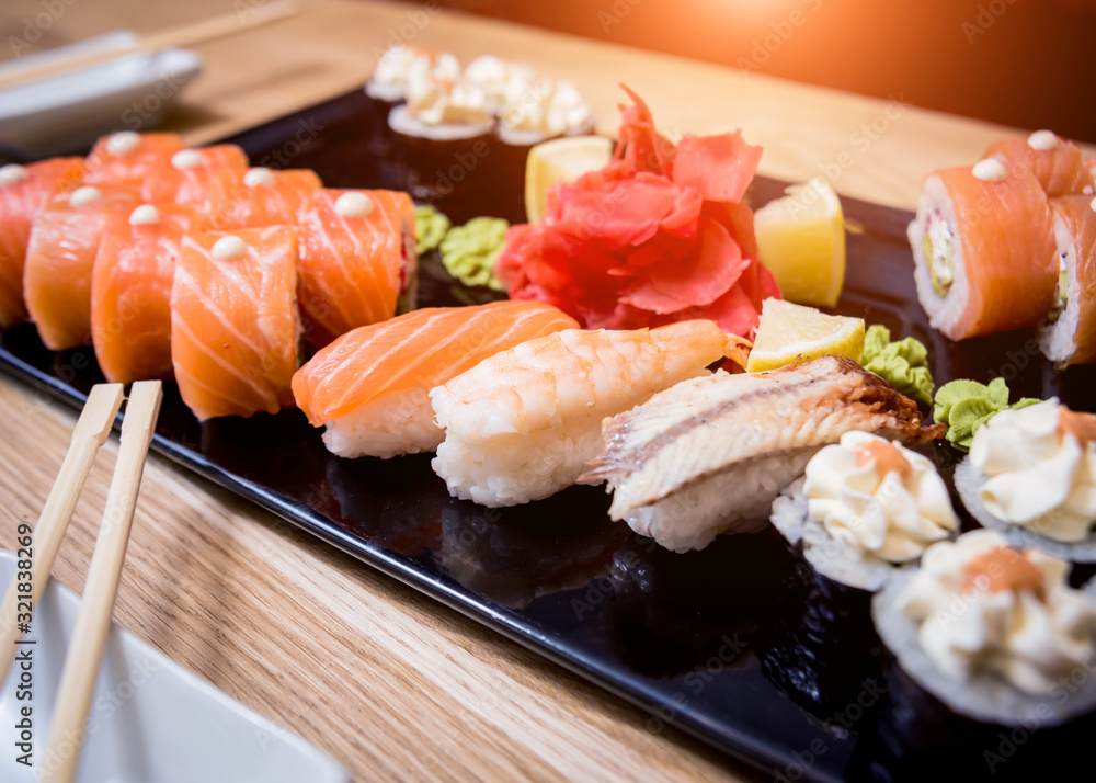 Sushi set. Rolls with salmon, eel and red caviar on a wooden plate. Restaurant. Sushi set. Rolls with salmon, eel and red caviar on a wooden plate. Restaurant.