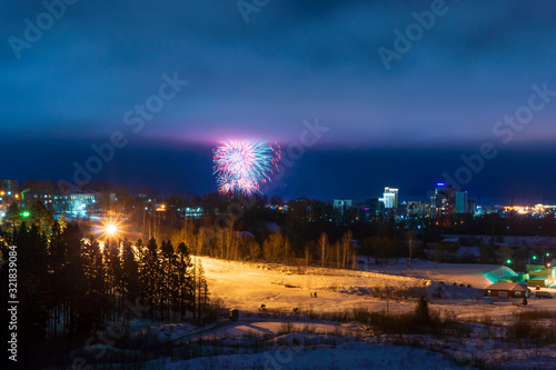 Fireworks in the night sky over city in winter landscape photo