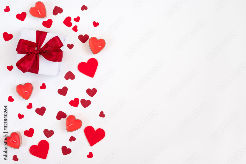 Valentines day composition. Greeting card with confetti hearts, candles and a gift on a white background. Valentines day concept.