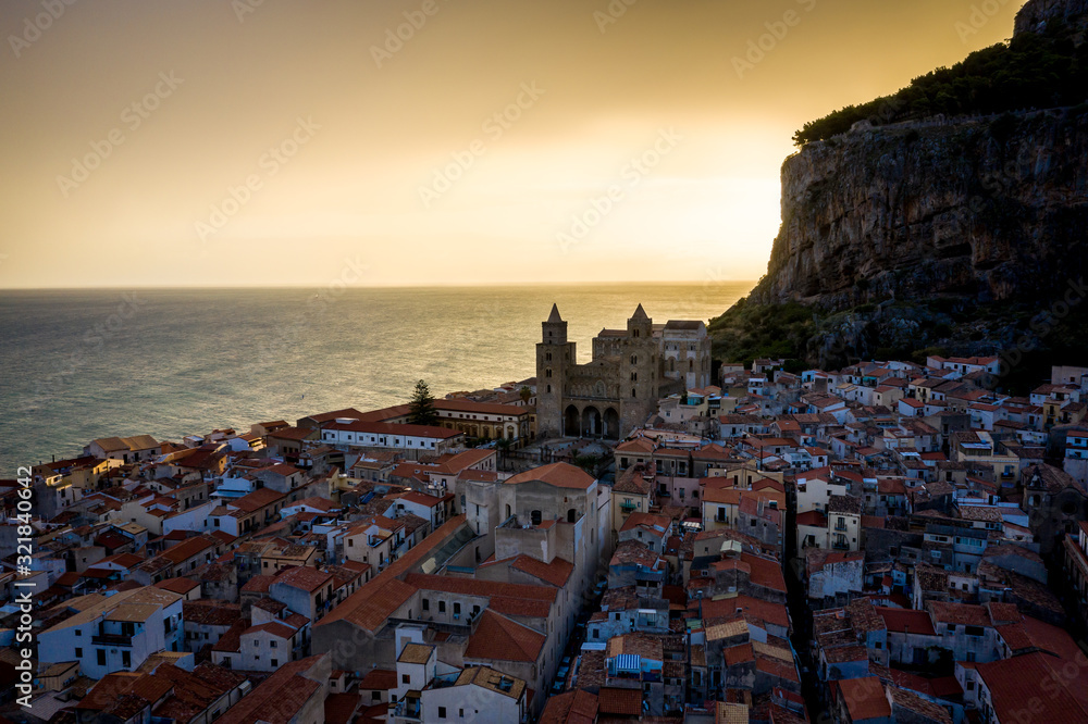 Panoramic view of the city of Cefalu from the sea. Contour light from the sun at dawn. Tyrrhenian Sea. Sicily, Italy