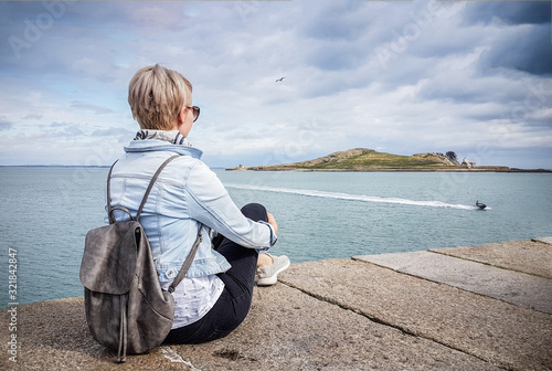 Canvas Print Female tourist looking over the island Eye of Ireland