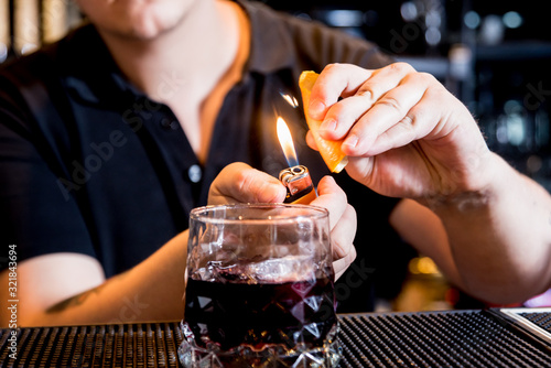 Bartender is making cocktail at bar counter. Fresh cocktails. Barman at work. 