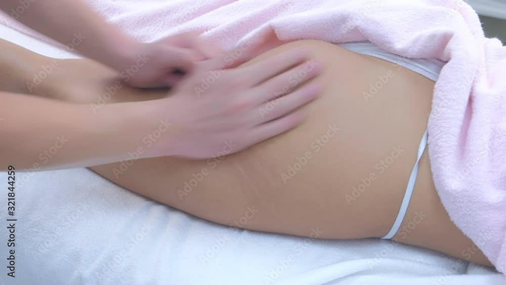 Man doctor making sculptural lift massage to woman rubbing leg and booty in clinic. Therapy techniques with pressing and slapping for athletic body of sportswoman. Procedure for health and beauty. Man doctor making sculptural lift massage to woman rubbing leg and booty in clinic. Therapy techniques with pressing and slapping for athletic body of sportswoman. Procedure for health and beauty.