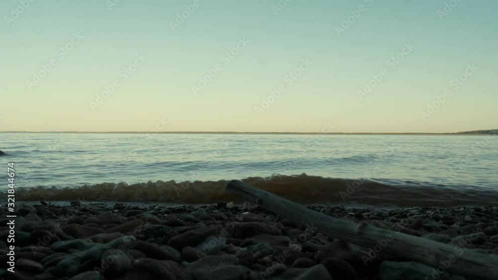 River waves at sunset. View from the bank of the river and the horizon River waves at sunset. View from the bank of the river and the horizon