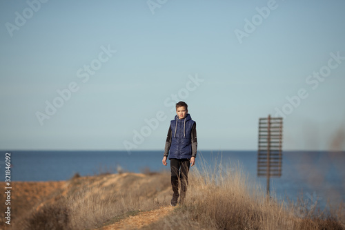 handsome guy walks along a road along the sea © rimmdream