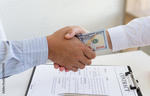  Businessmen make dollar payments while signing an investment agreement to be a partner in an illegal and successful manner, Bribery and corruption concept.. photo