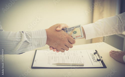  Businessmen make dollar payments while signing an investment agreement to be a partner in an illegal and successful manner, Bribery and corruption concept.. photo