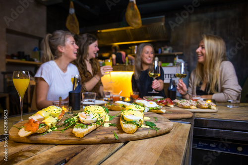 Girls having fun during a brunch with wine and food