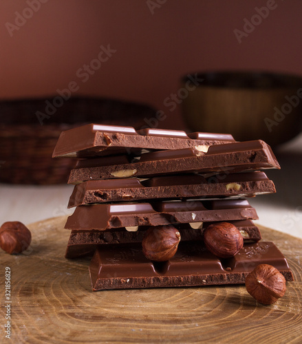 Chocolate bar with hazelnut on a wooden background.