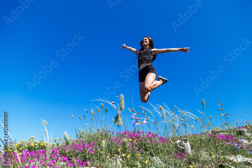 Beautiful, young girl jumps on the slope of a ridge.  Late spring (early summer) Gelendzhik.