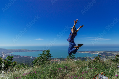 Girl jumps on the slope of a ridge. Late spring (early summer) Gelendzhik.