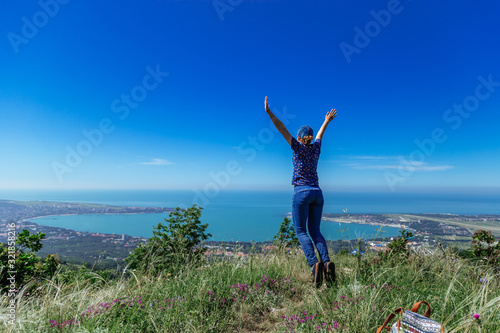 Girl jumps on the slope of a ridge. Late spring (early summer) Gelendzhik.