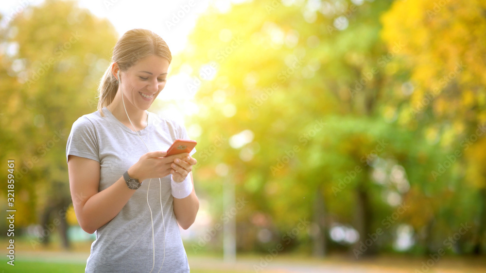 The athlete is training in the park at dawn. The athlete runs along the track, selects and listens to music with headphones. Healthy lifestyle. The athlete is training in the park at dawn. The athlete runs along the track, selects and listens to music with headphones. Healthy lifestyle.