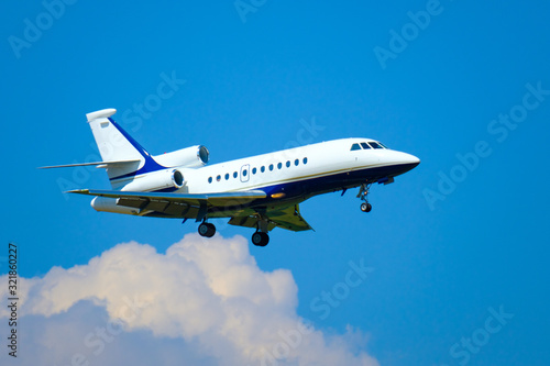Small private jet airplane preparing for landing at day time in international airport