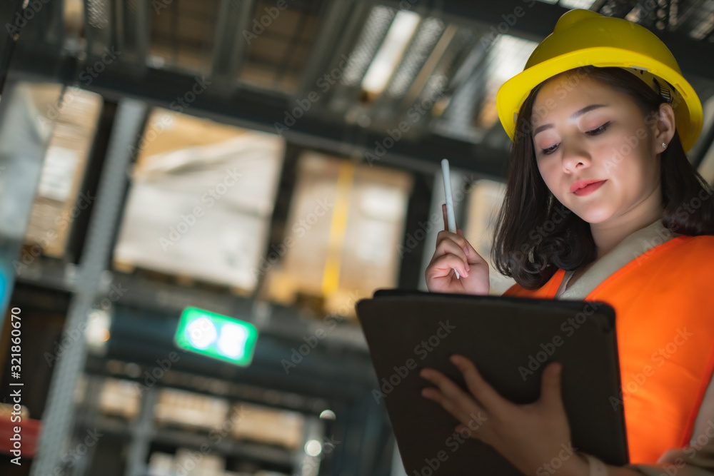 Pretty worker checking stock in the warehouse. Asian beautiful young woman worker of furniture store.Businesswoman using tablet in distribution stock.