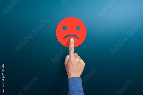 Fototapeta The client's hand choose the red sad face icon, Customer service evaluation, dis