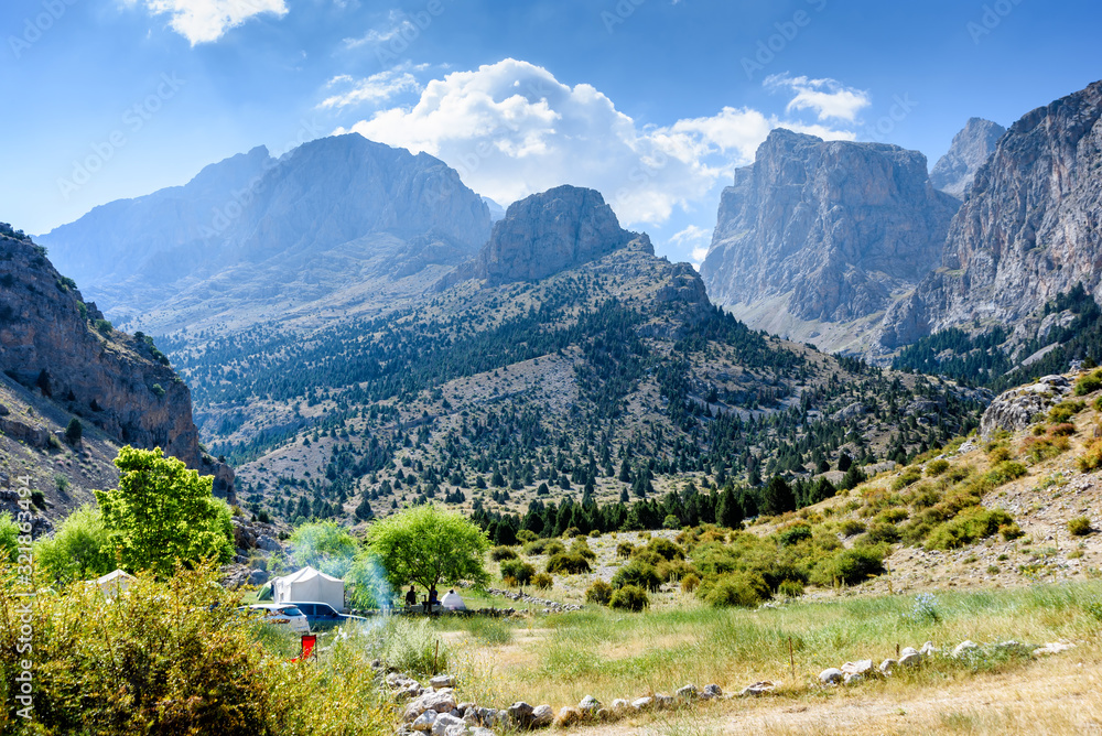 Mountain landscape with trees, tents, cars in the Turkish national Park aladag in summer day