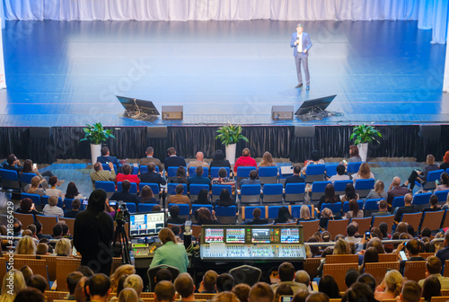 Visitors of business education forum listen to lecture in large hall