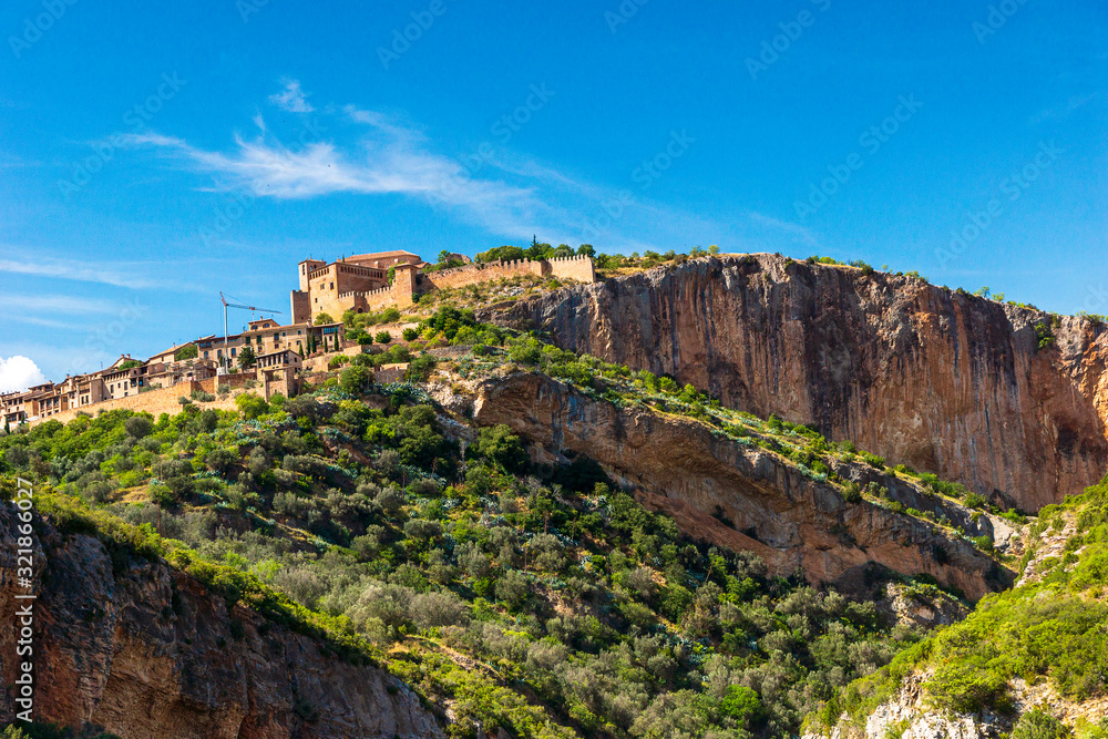 Alquezar picturesque image of the village on top of the mountain with green vegetation and blue sky