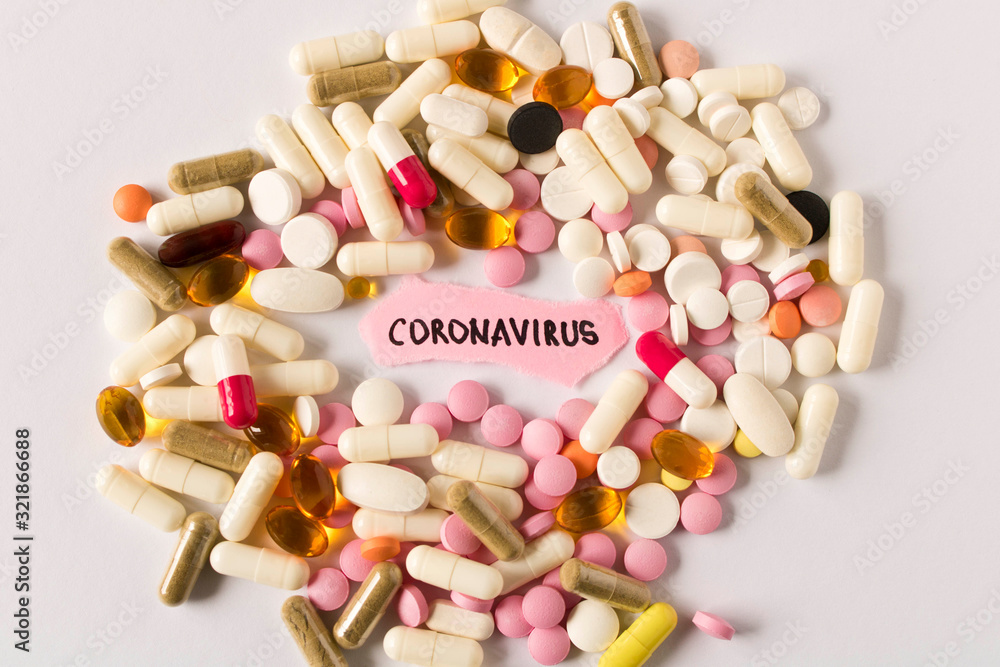 Coronavirus. 2019-nCoV.  A scattering of pills and the inscription CORONAVIRUS on a piece of paper on a light background. The concept of virus protection. Selective focus