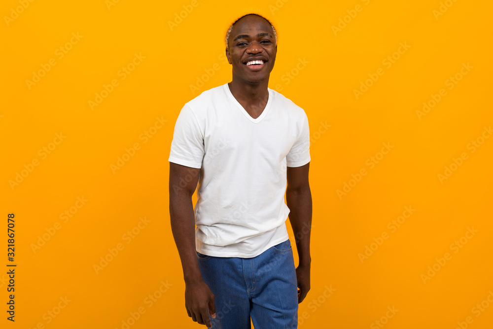 attractive african guy in a white t-shirt on a yellow background with copy space attractive african guy in a white t-shirt on a yellow background with copy space