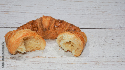 Traditional french butter croissant on white wooden background