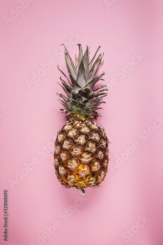 Close up ripe pineapple on a pink background. Copy space. Vertical shot