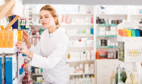 Woman pharmacist arranging drugs