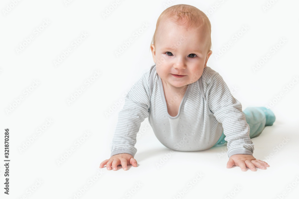 Smiling cute little baby boy is lying leaning hands on the floor and looking at the camera. All is on the white background Smiling cute little baby boy is lying leaning hands on the floor and looking at the camera. All is on the white background