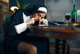Sexy nun in a cassock sniffing cocaine