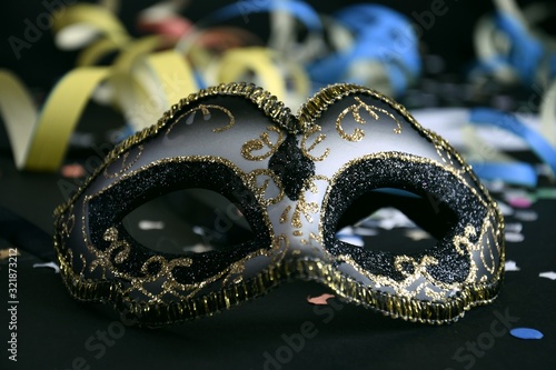 carnival masks with confetti and streamers on a black background