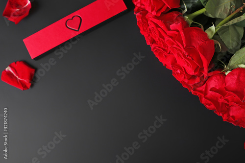 Scarlet roses with a red box on a dark background