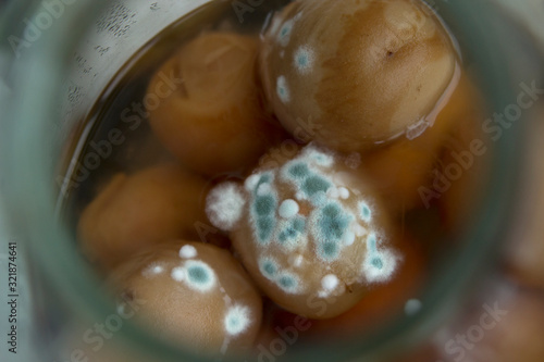 Blue, green, white mold on products, on a peach compote. Harm to mold. photo
