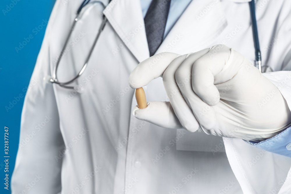 Doctor holding suppository for hemorrhoid treatment on blue background, closeup Doctor holding suppository for hemorrhoid treatment on blue background, closeup