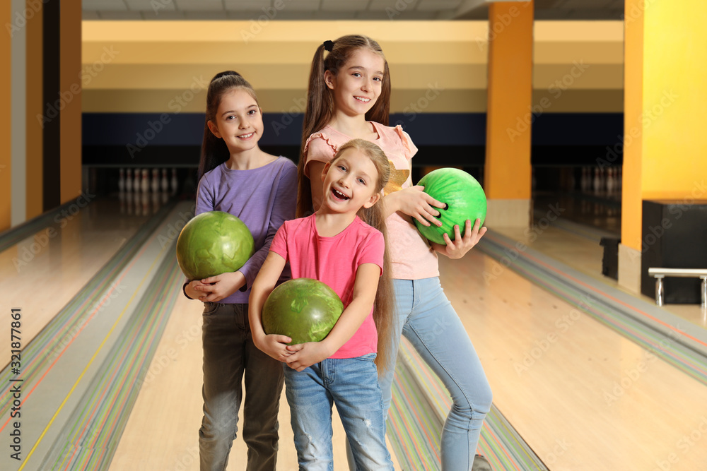 Fototapeta premium Happy girls with balls in bowling club