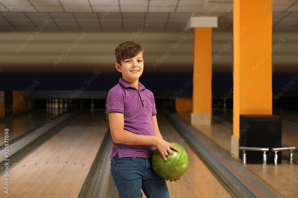 Fototapeta premium Preteen boy with ball in bowling club