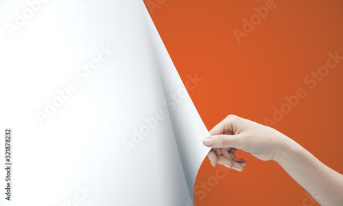 Woman hand turning orange page