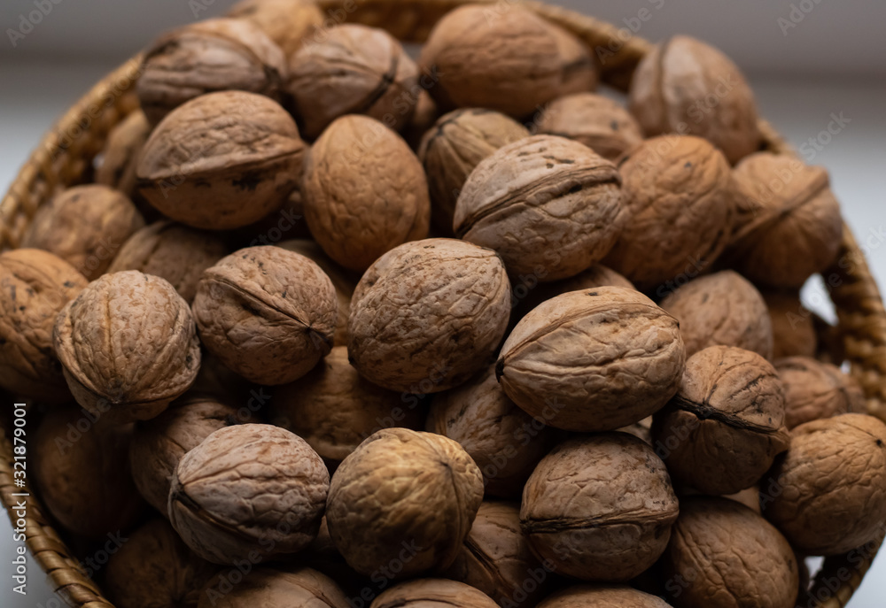 Walnuts close-up. A lot of nuts in a small basket. Background Walnuts close-up. A lot of nuts in a small basket. Background