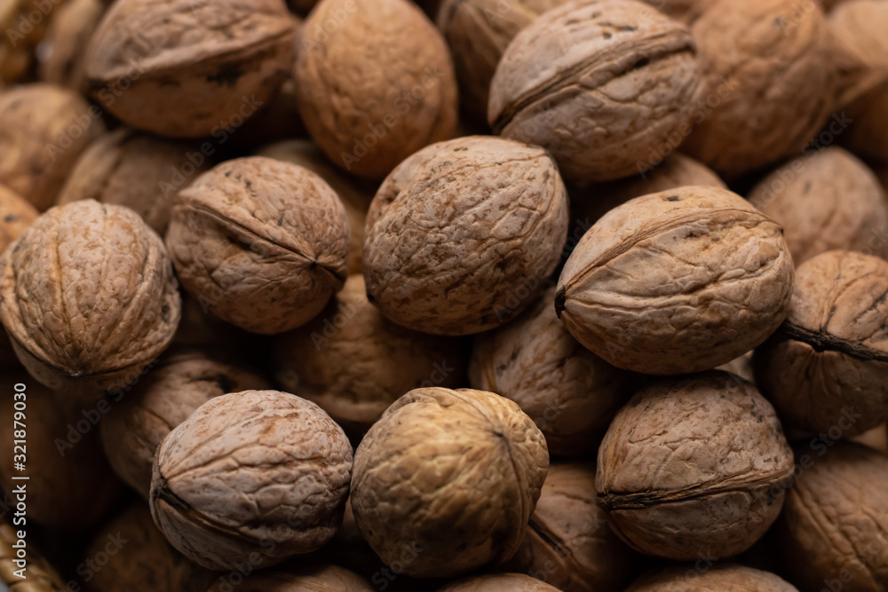 Walnuts close-up. A lot of nuts in a small basket. Background Walnuts close-up. A lot of nuts in a small basket. Background