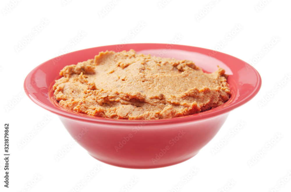 Plate with hummus - spread made from cooked, mashed chickpeas blended with tahini, lemon juice, garlic and dried tomatoes isolated on white background. Clipping path added