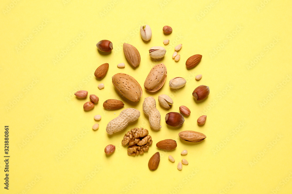 Different delicious nuts on yellow background, flat lay Different delicious nuts on yellow background, flat lay