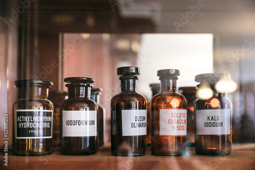 Dark glass potion bottles with medicines in an old pharmacy in a wooden cabinet