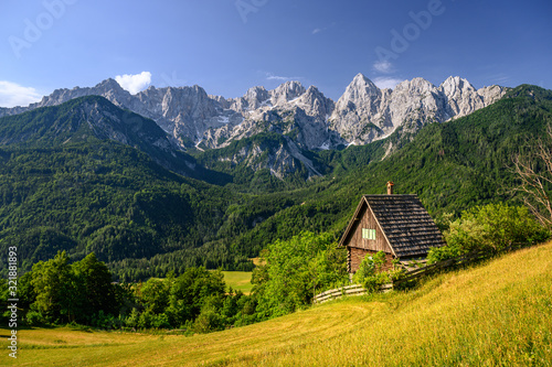 chalet in front of an impressive mountain backdrop Julian Alps in Kranjska Gora, Slovenia