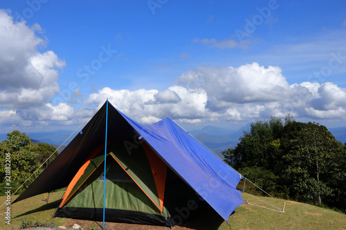 A tent is spread, with beautiful skies and clouds.