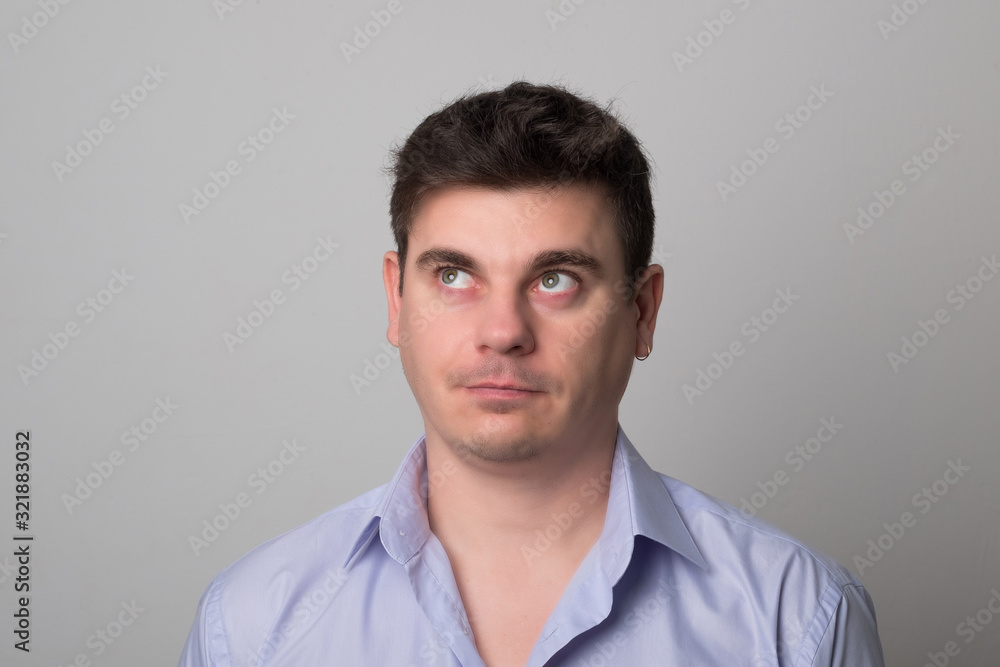 Man looks up studio image. Pretty man with dark hair.