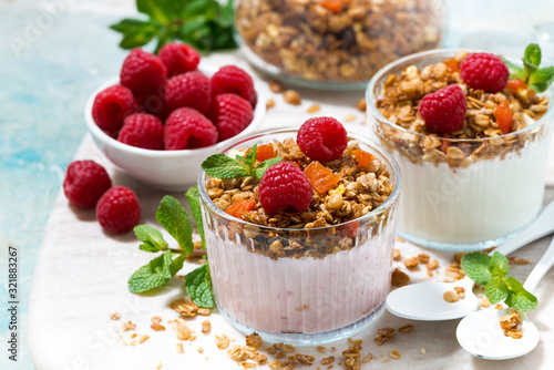 dessert with homemade granola, fresh raspberries, fruit and natural yoghurt on board